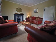 Comfortable guest lounge with settees and wood burning stove